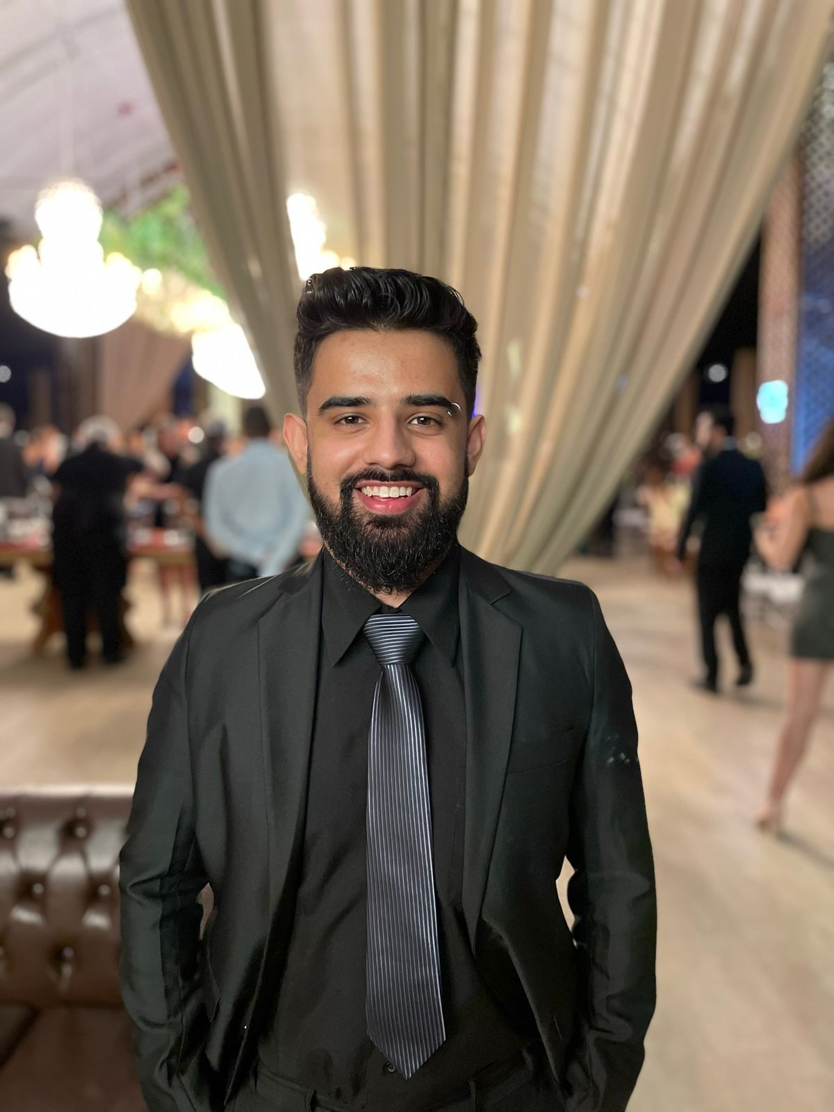 Thainan Prado, desenvolvedor full stack sênior e consultor de software sob medida, sorrindo, de terno escuro